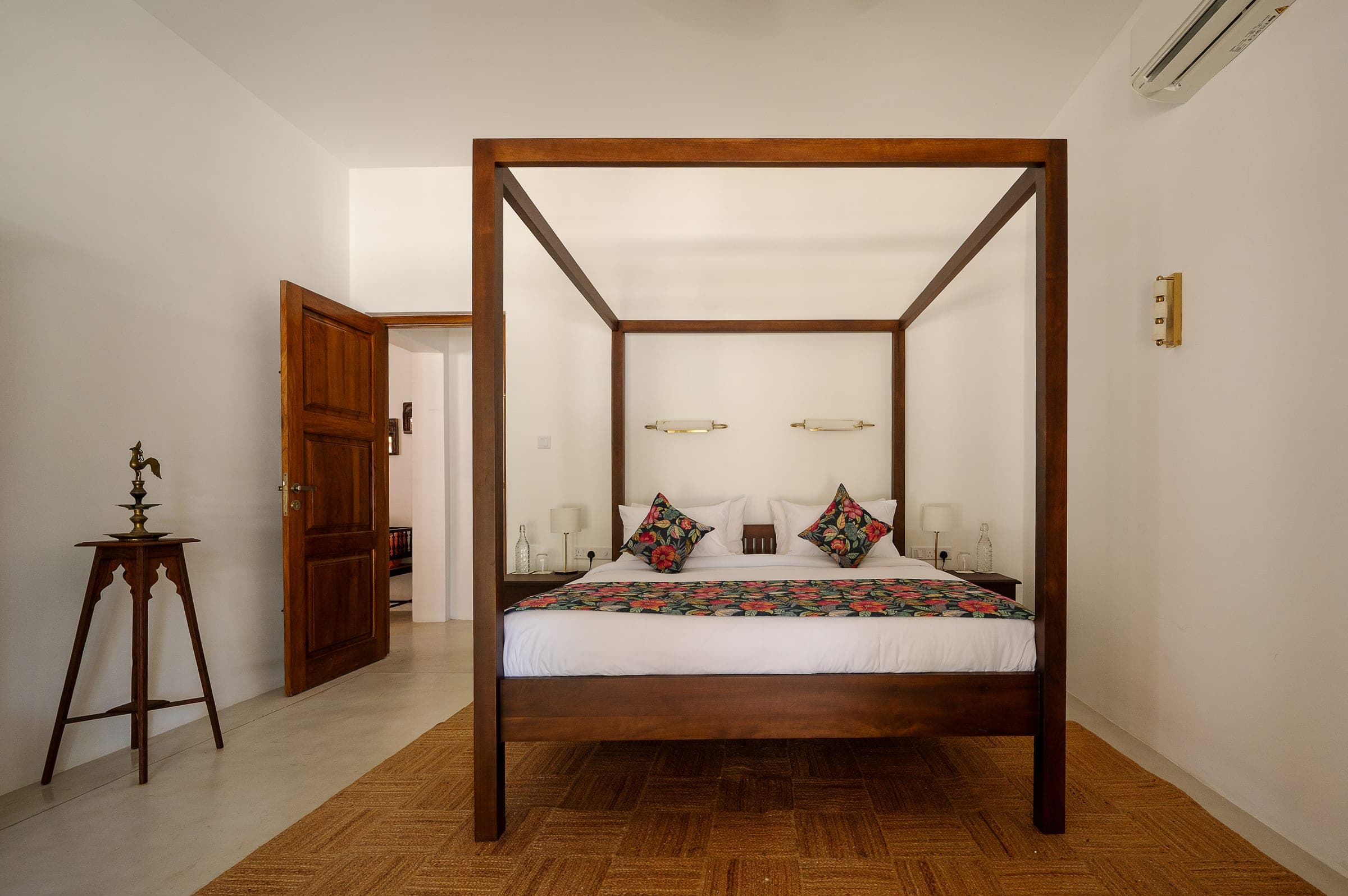 Bedroom Two: a teak four-poster bed dressed in white linen with block-print cushions