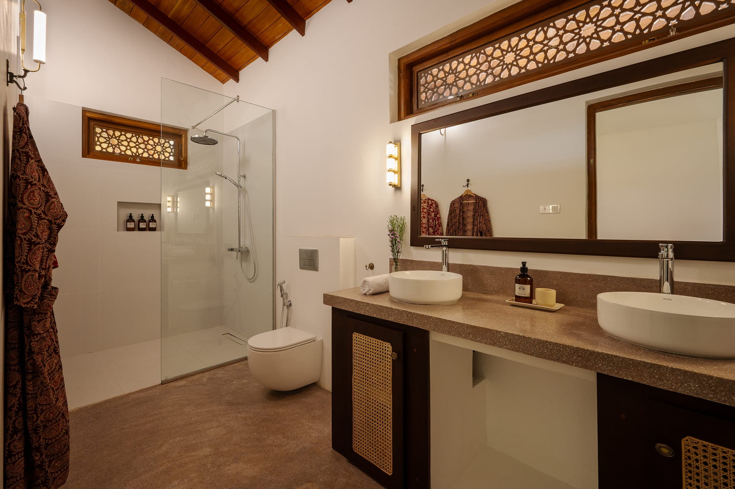 Ensuite bathroom with a walk-in rain shower, double vanity and a fretwork window under the timber ceiling